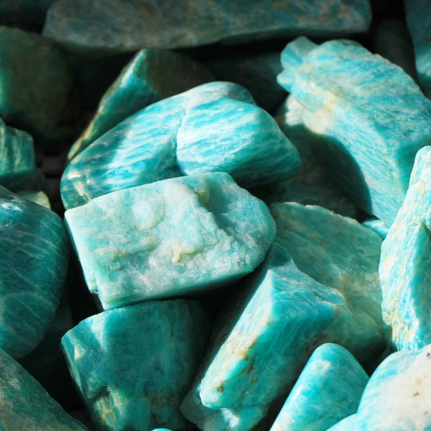 Close-up of unique Amazonite crystal pieces in soothing blue-green hues with natural texture and patterns