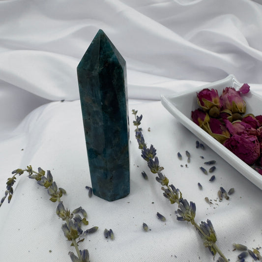 Davinas Apatite Tower Point crystal standing on white fabric with lavender sprigs and dried rose petals