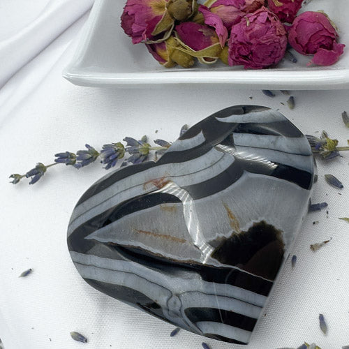Davinas Black Stripe Agate Heart polished stone with black and white stripes on white background