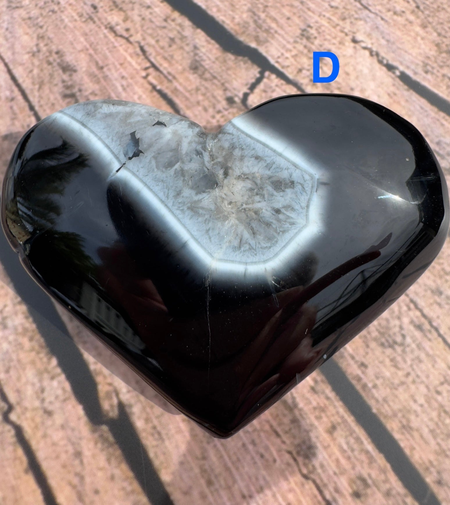 Davinas heart-shaped black stripe agate stone with a polished surface and natural crystal center