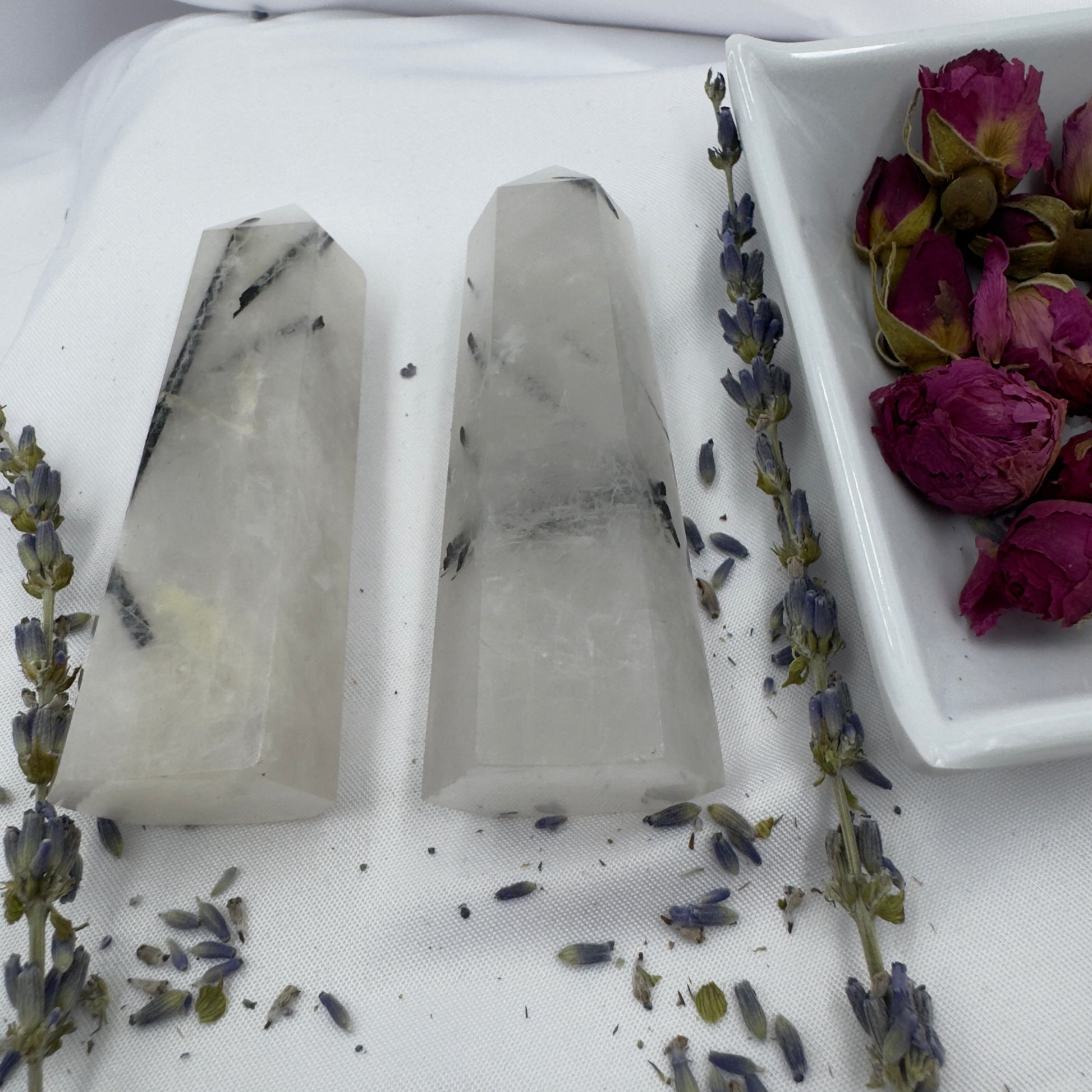 Davinas black tourmaline tower crystal points displayed with dried lavender and rose petals on white fabric