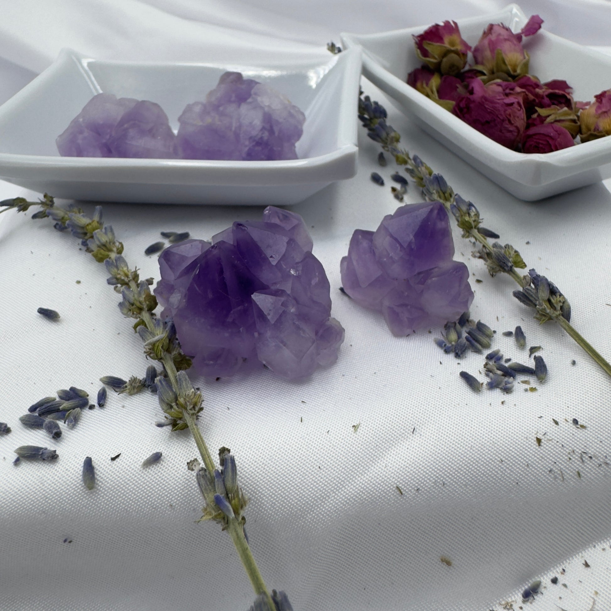 Purple amethyst mini clusters displayed with dried lavender and roses on white trays to buy amethyst mini clusters