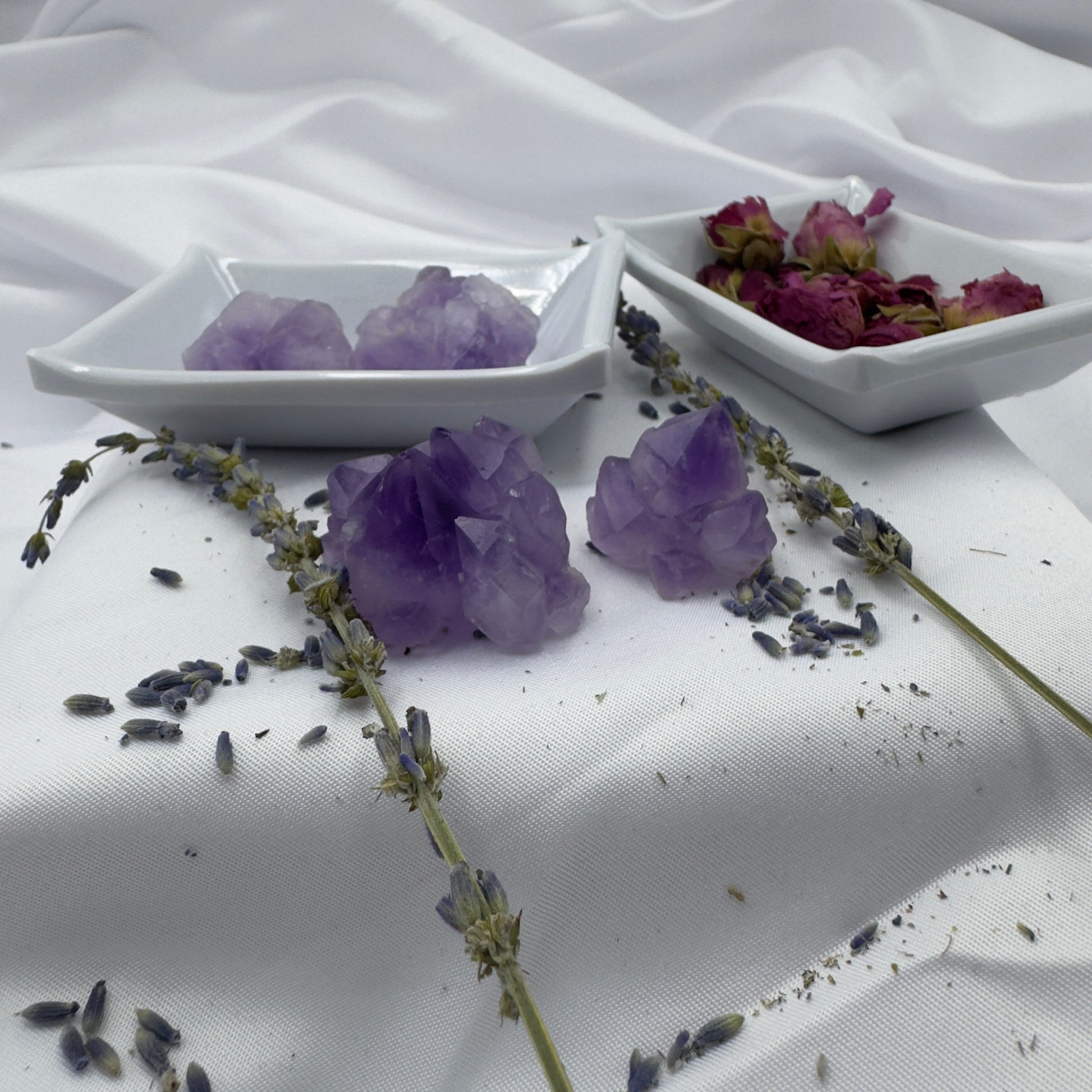 Buy amethyst mini clusters displayed on white dishes with lavender sprigs and dried rose petals
