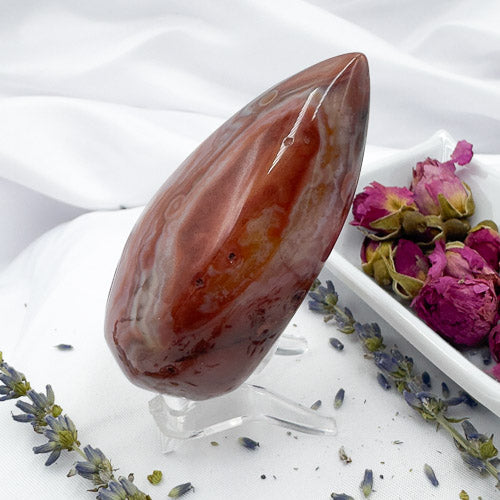 Davinas Carnelian Geode Druzy Freeform polished stone standing on clear stand with dried flowers background