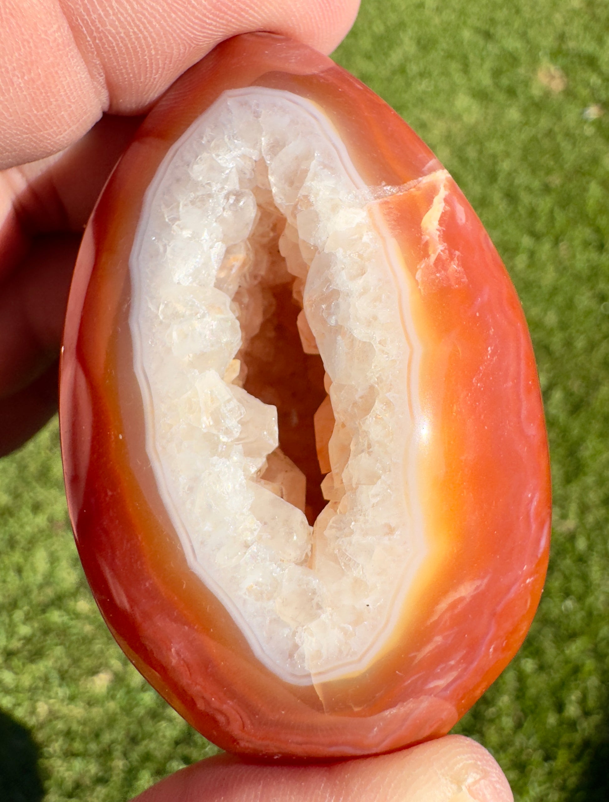 Davinas Carnelian Geode Druzy Freeform with vibrant orange and white crystals held in hand