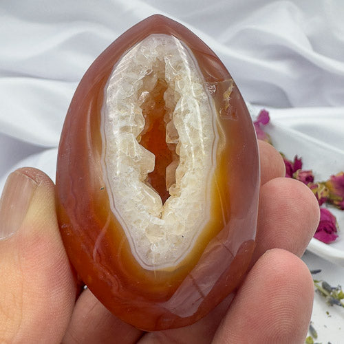 Close-up of Davinas Carnelian Geode Druzy Freeform held in hand showing orange and white crystal details