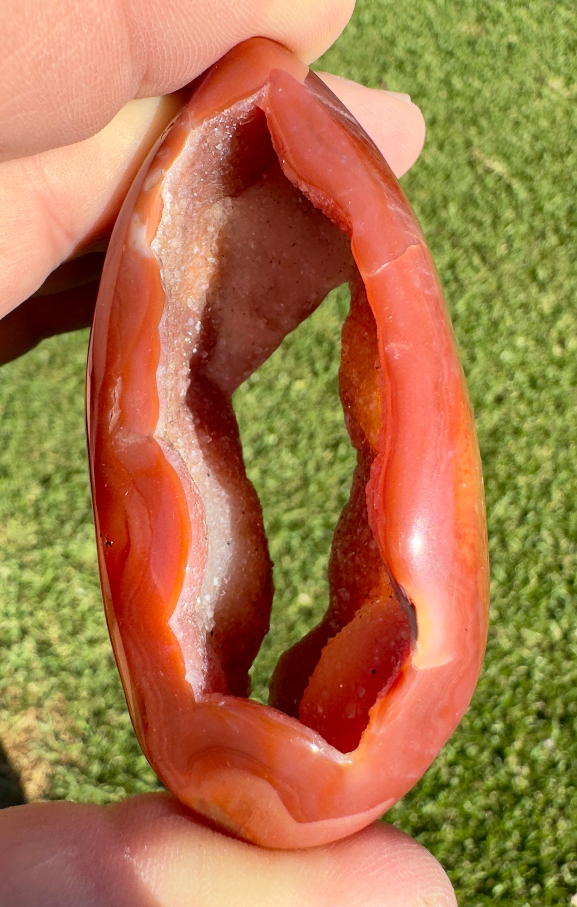 Davinas Carnelian Geode Druzy Freeform with polished orange exterior and sparkling crystal interior held in hand