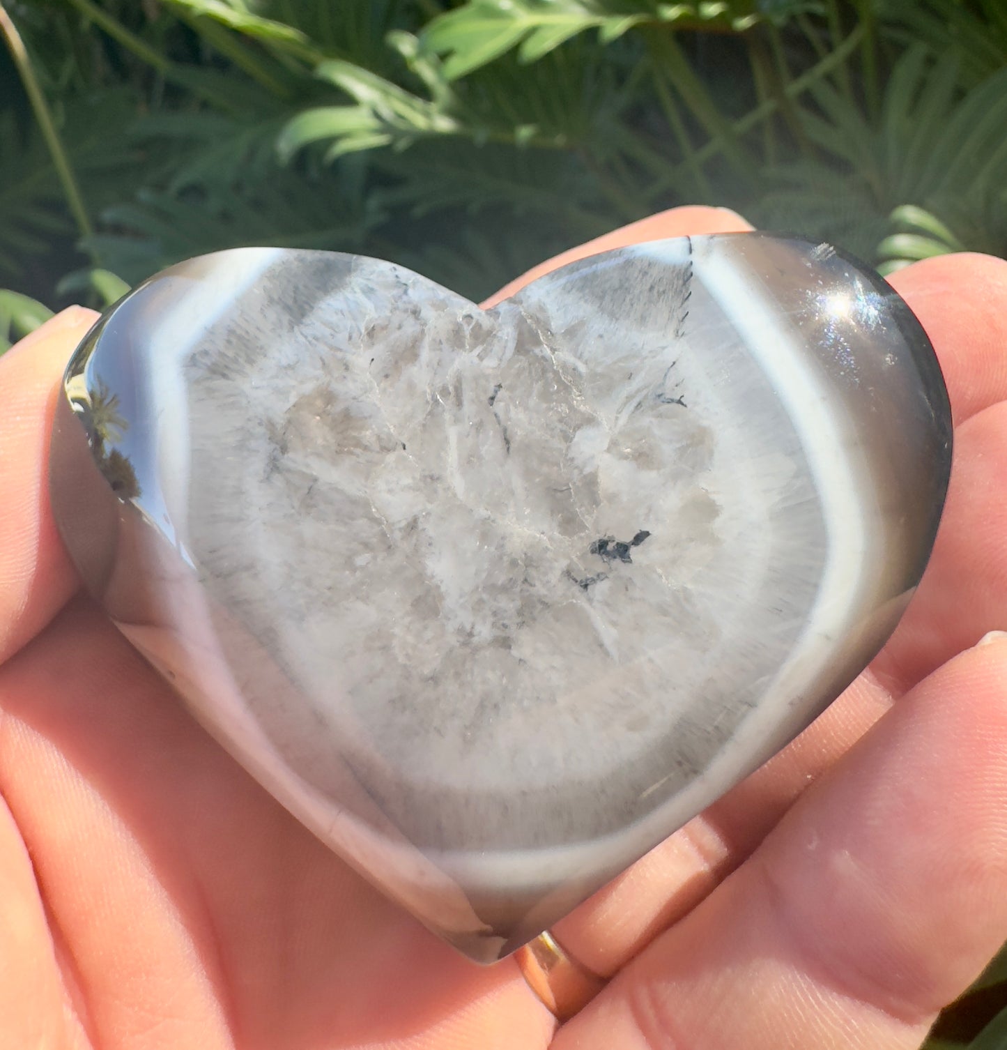 Heart-shaped polished crystal stone held in hand featuring premium crystal gifts Davinas design