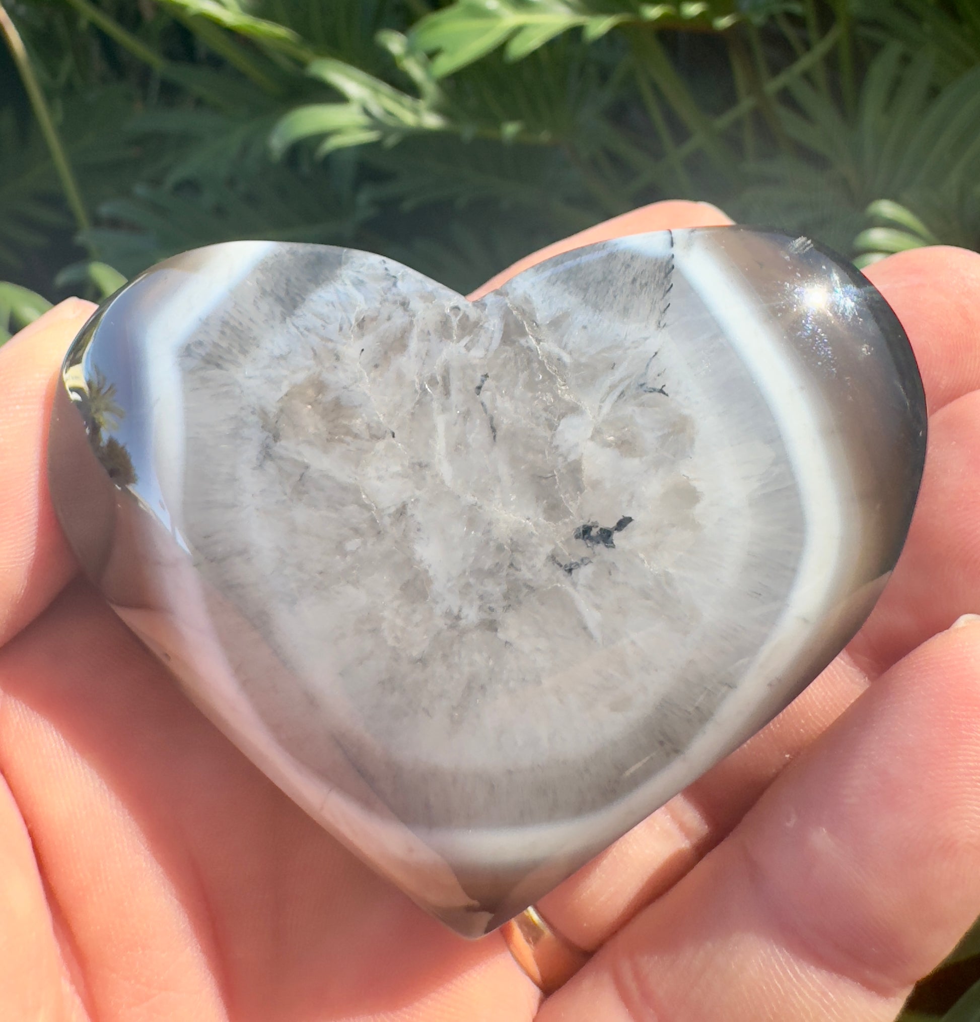 Heart-shaped polished crystal stone held in hand featuring premium crystal gifts Davinas design