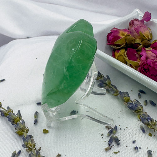 Green heart-shaped fluorite crystal displayed with dried flowers as a fluorite love gift