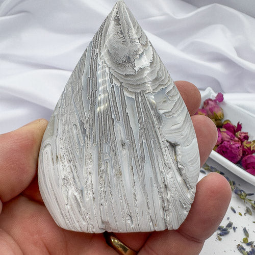 Hand holding a handcrafted agate for collection with natural gray and white patterns by Davinas