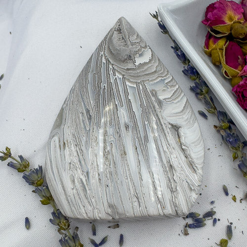 Handcrafted agate for collection with natural striped patterns surrounded by dried flowers