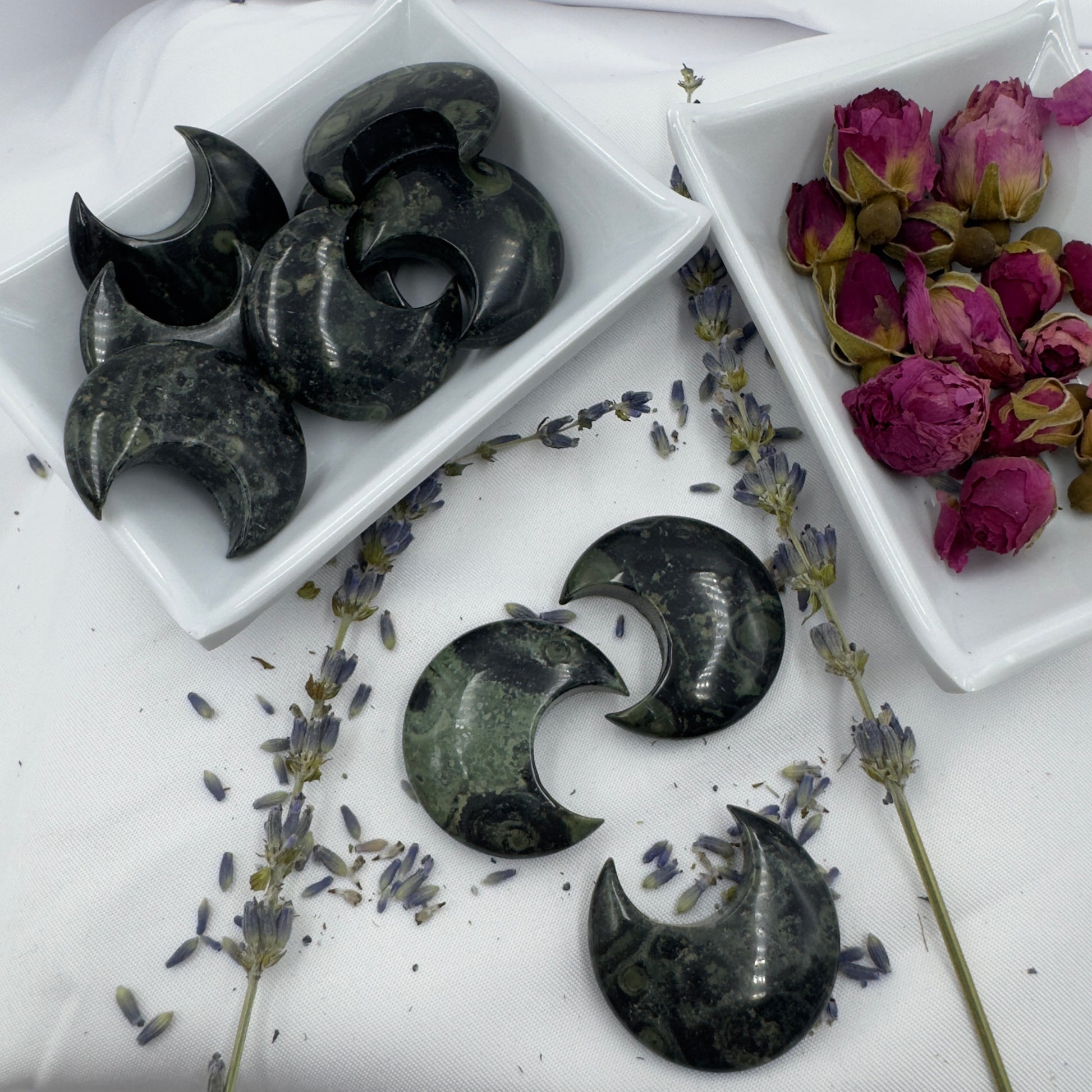 Davinas Kambaba Jasper Moon stone crescent shapes displayed with dried lavender and rose buds on white fabric