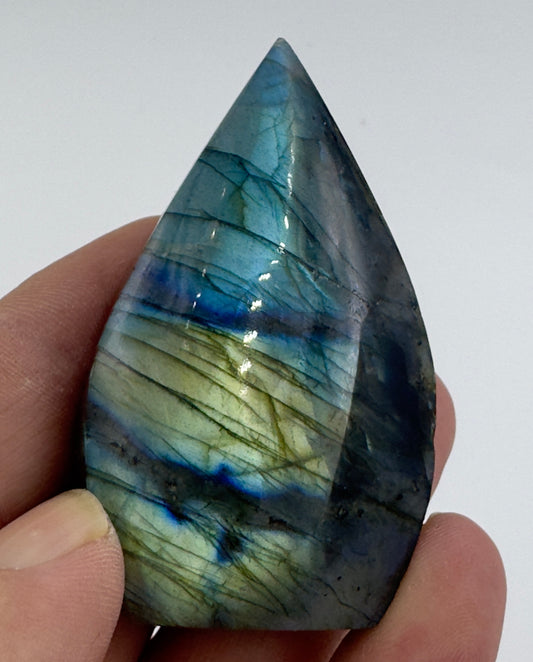 Davinas Labradorite freeform crystal held between fingers showing blue and green iridescent colors