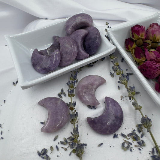 Davinas polished Lepidolite moon crystal crescent shapes displayed with dried lavender and rose buds