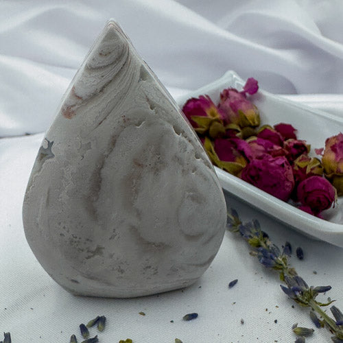 Davinas Morocco agate freeform stone with natural swirling patterns displayed with dried flowers on white cloth