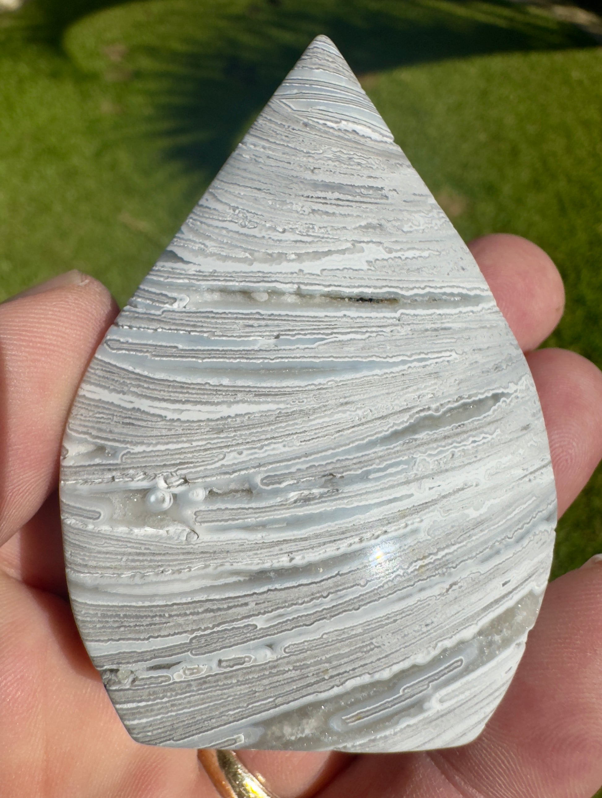 Davinas Morocco agate freeform stone with natural white and gray banded patterns held in hand