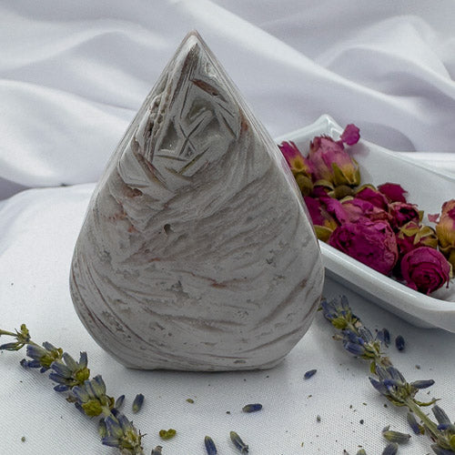 Davinas Morocco agate freeform stone with natural patterns displayed with dried flowers on white fabric