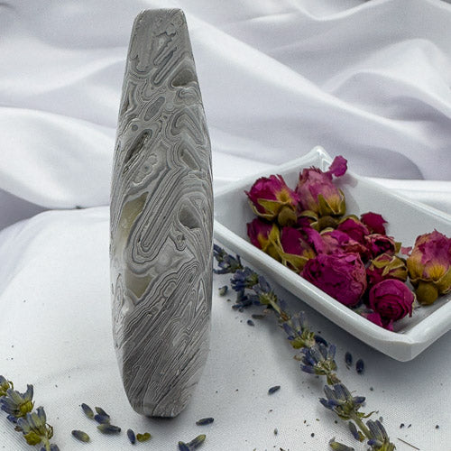 Davinas Morocco agate stone standing upright with dried flowers and lavender on white fabric background