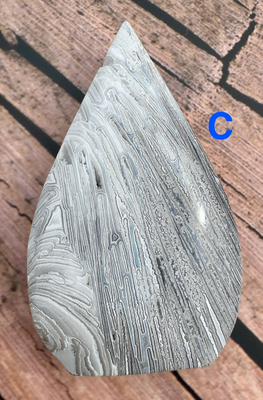 Davinas Morocco agate stone with natural white and gray banded patterns on wooden surface