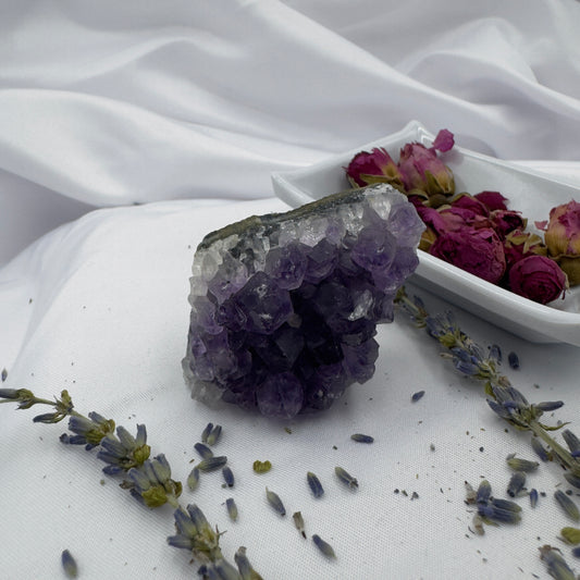 Davinas premium amethyst clusters displayed with dried lavender and rose buds on white fabric