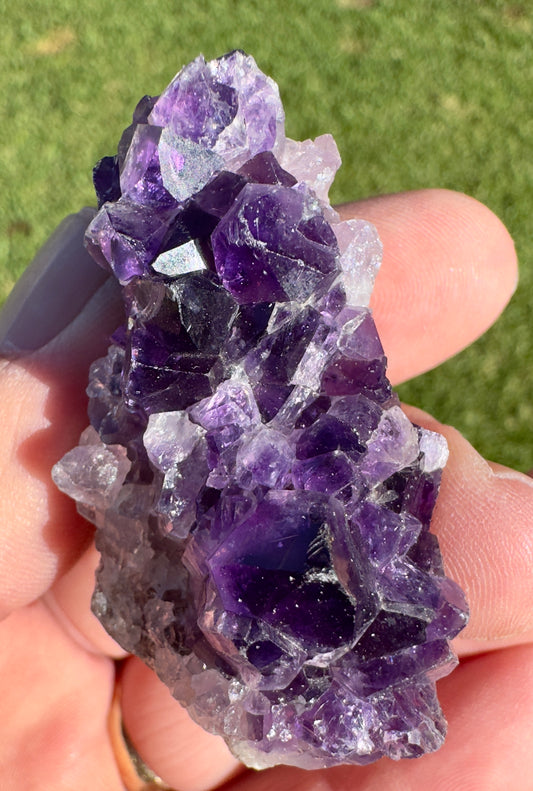 Davinas raw amethyst crystal cluster held in hand showing deep purple crystals and natural formation