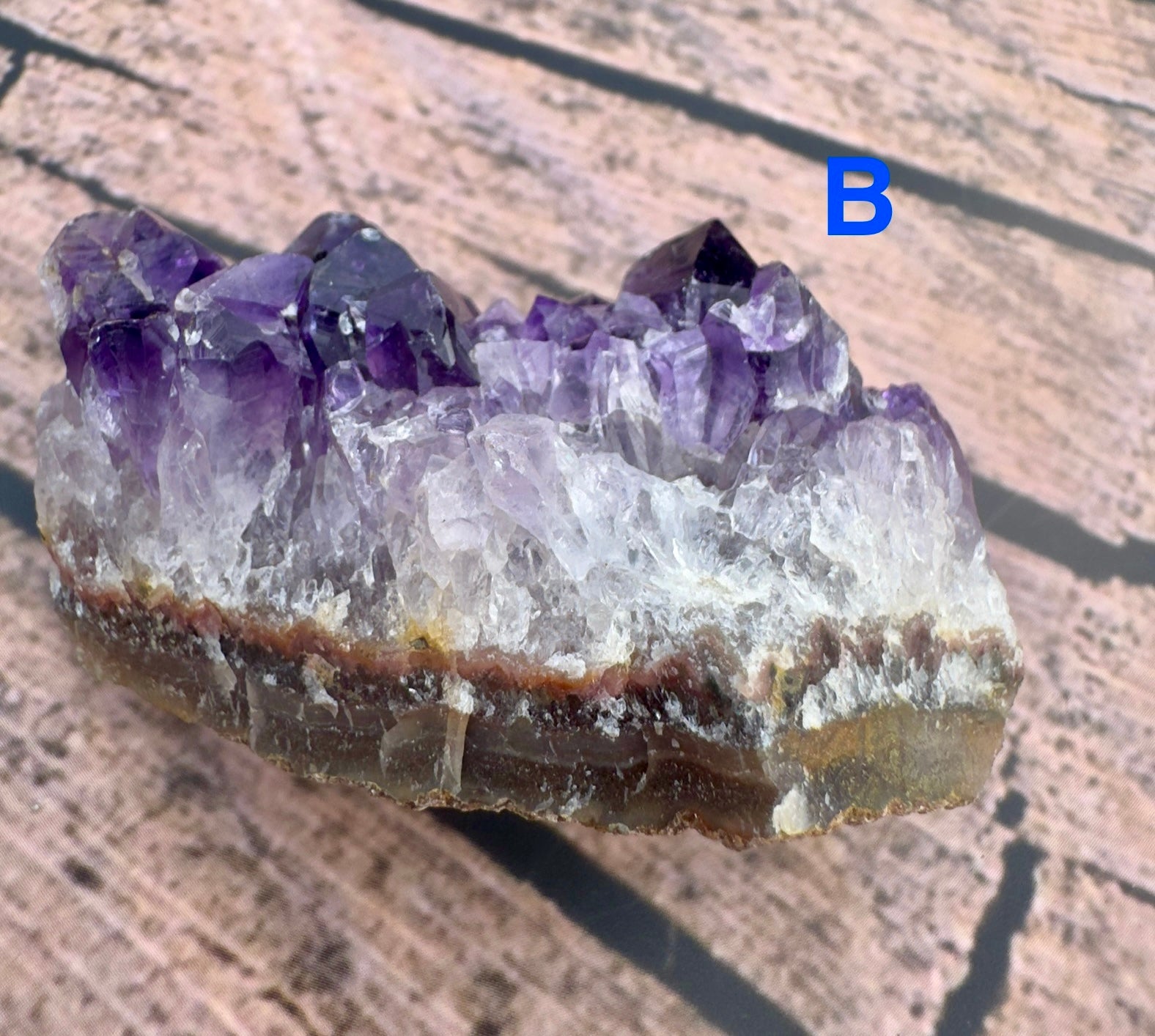 Davinas raw amethyst crystal cluster with purple and clear quartz points on a wooden surface