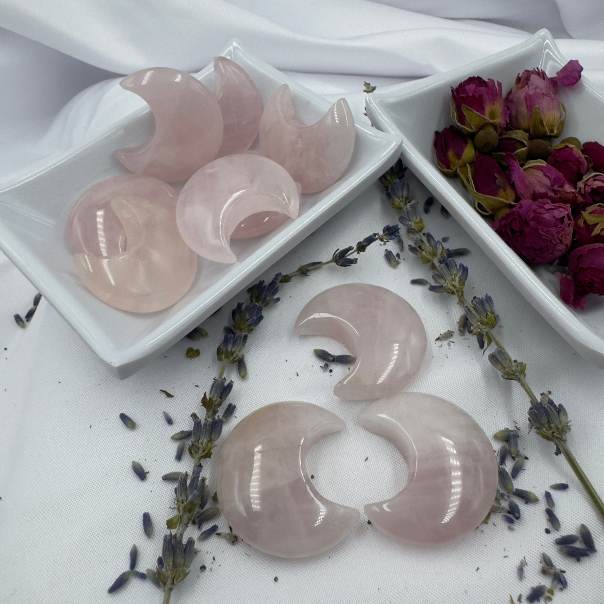 Davinas rose quartz moon crystal stones displayed with dried lavender and rose petals on white fabric