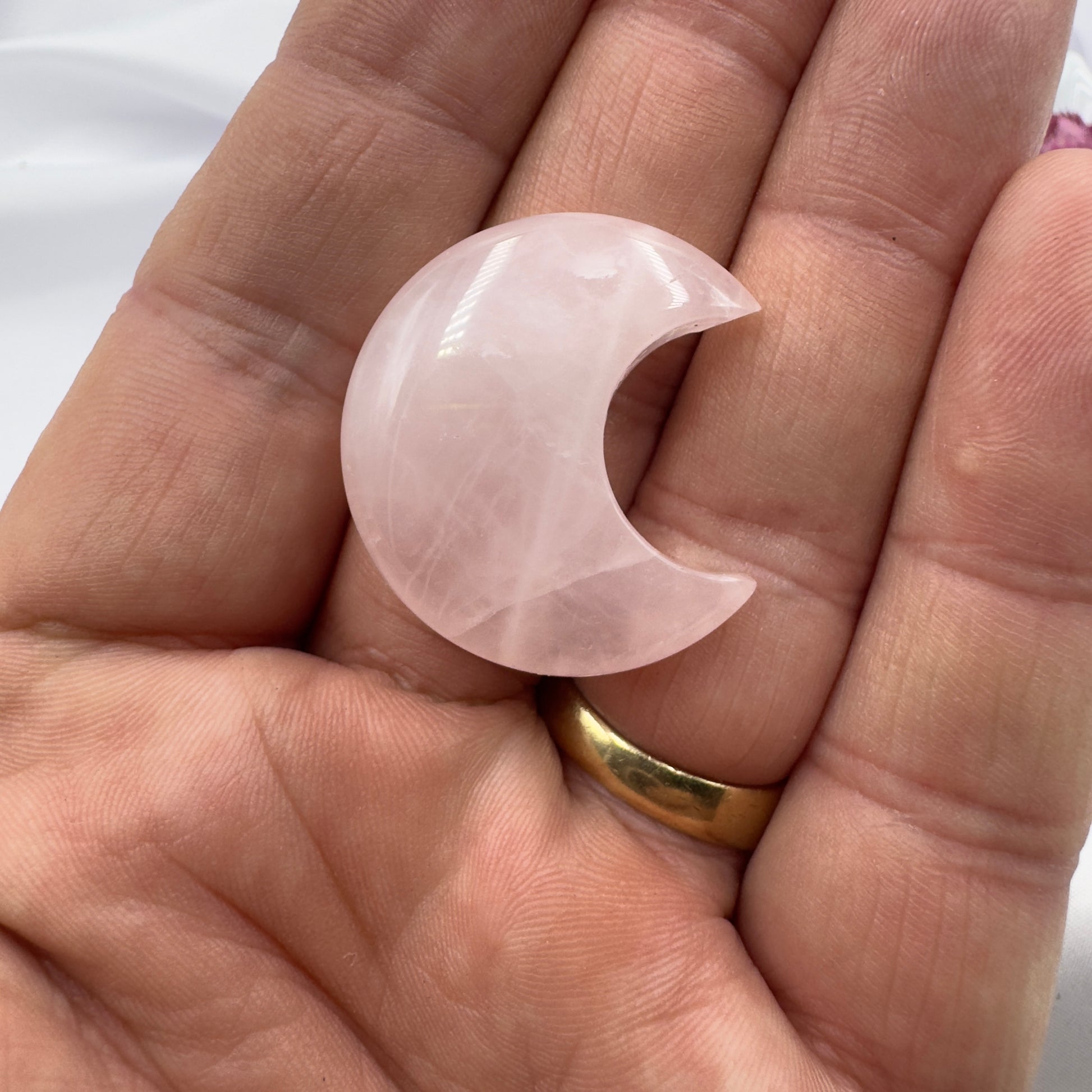 Davinas rose quartz moon crystal held in hand showing smooth polished crescent shape