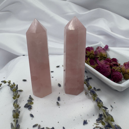 Davinas rose quartz tower point crystals displayed with dried flowers on white fabric background