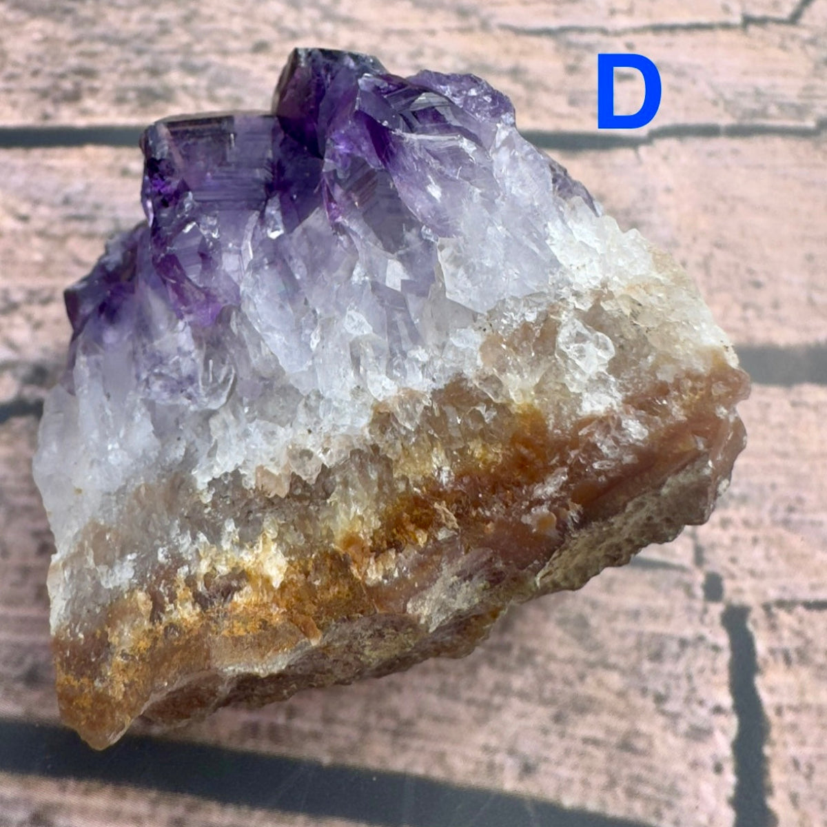 Davinas amethyst raw crystal cluster with purple and white crystals on a natural brown base