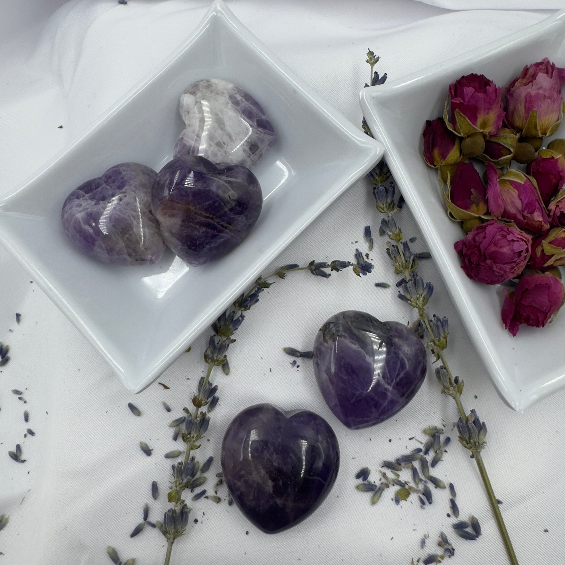 Davinas chevron amethyst heart crystals displayed in white dishes with dried lavender and rosebuds