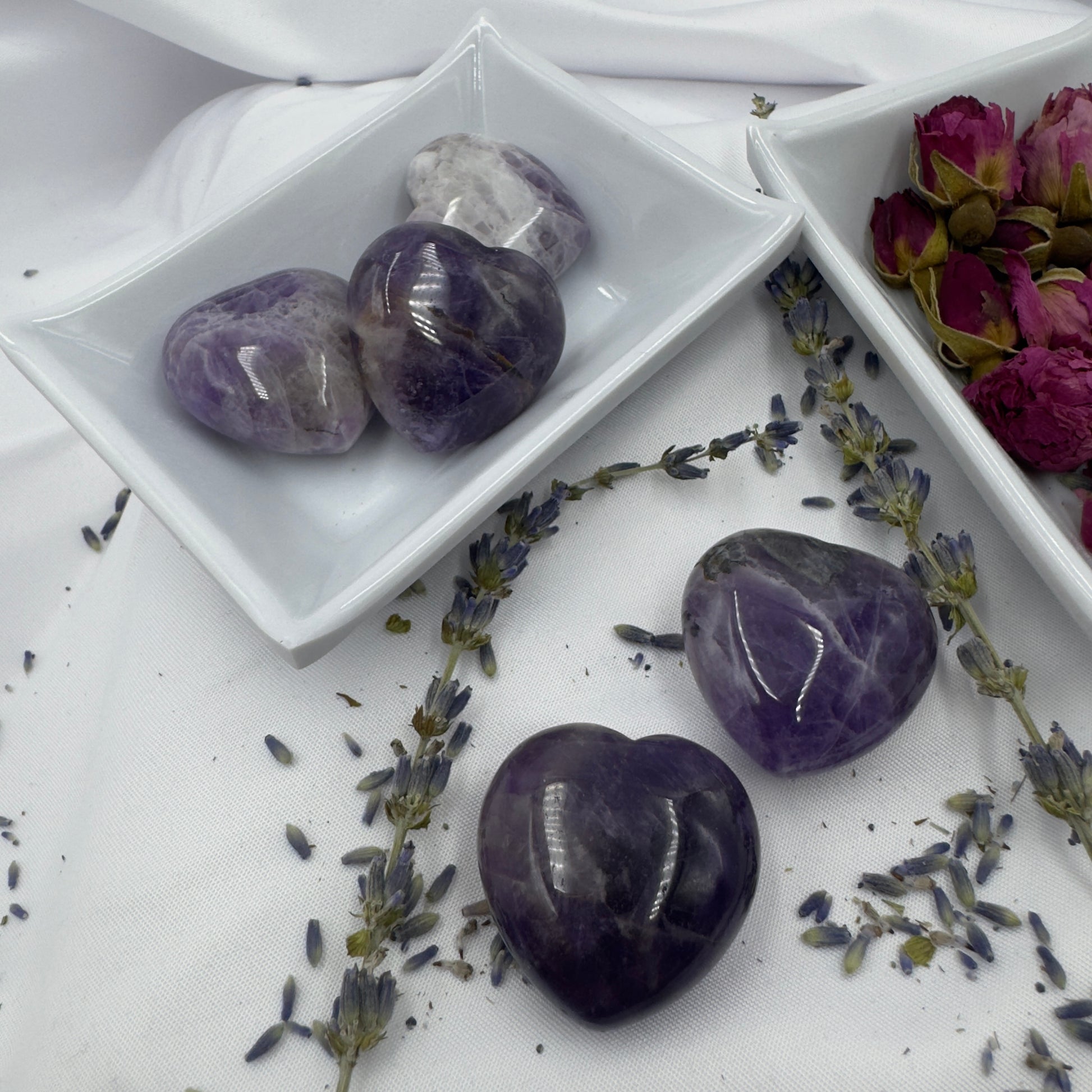 Davinas chevron amethyst heart crystals displayed on a white tray with dried lavender and rose petals