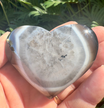 Heart-shaped polished crystal stone held in hand featuring premium crystal gifts Davinas design