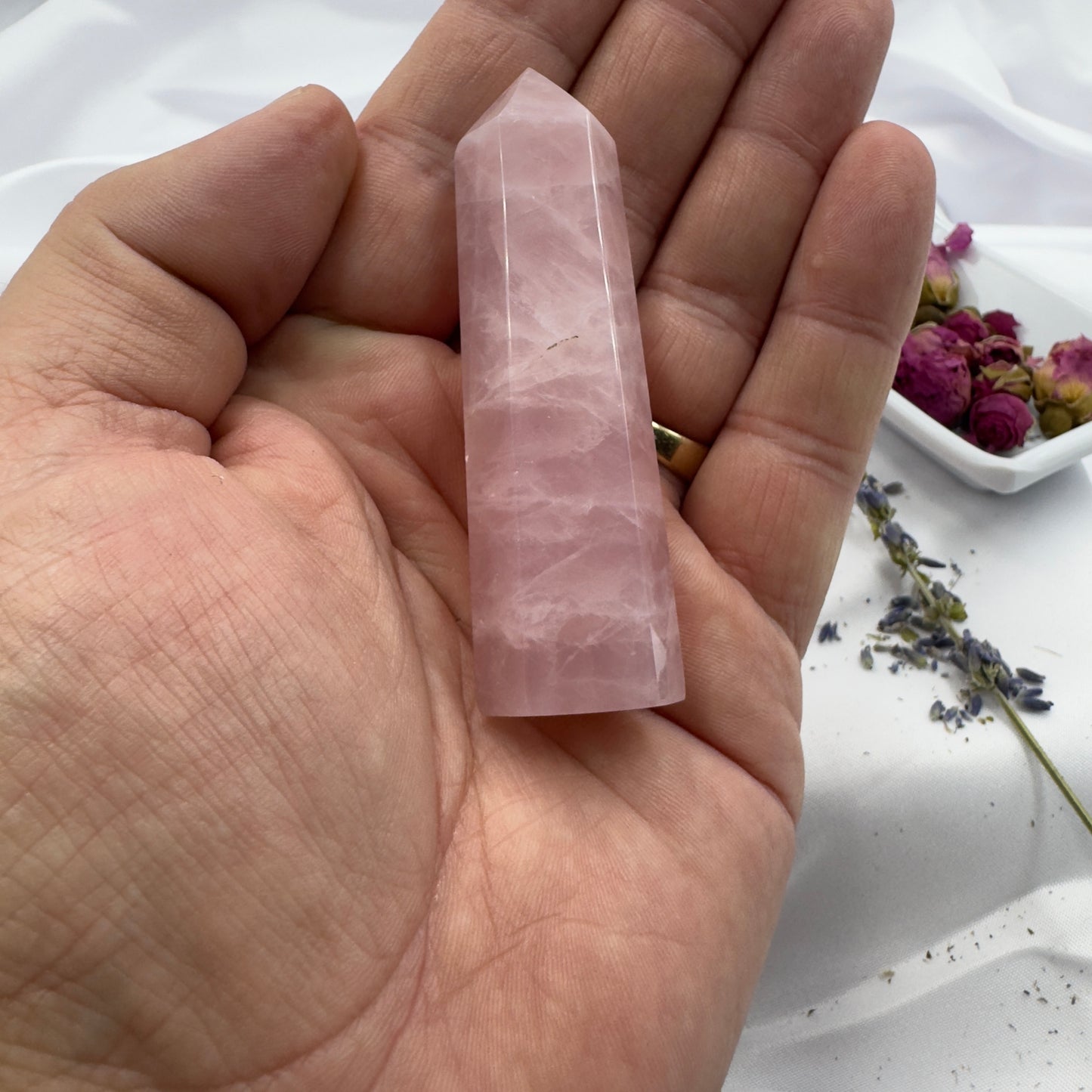 Davinas rose quartz tower point held in hand with dried flowers in the background