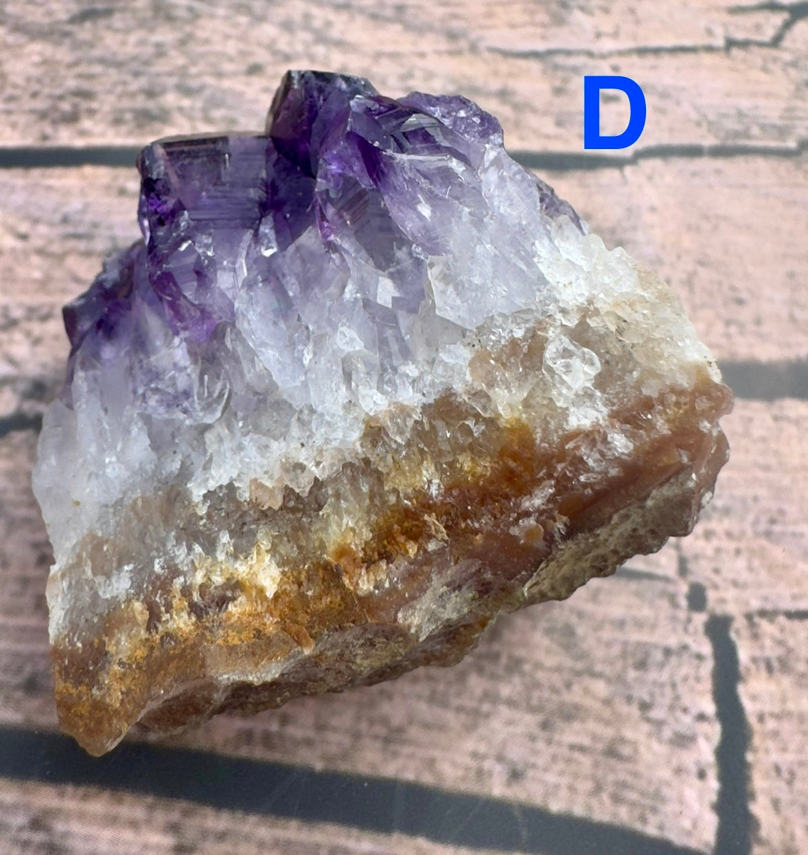 Davinas amethyst raw crystal cluster with purple and white crystals on a natural brown base